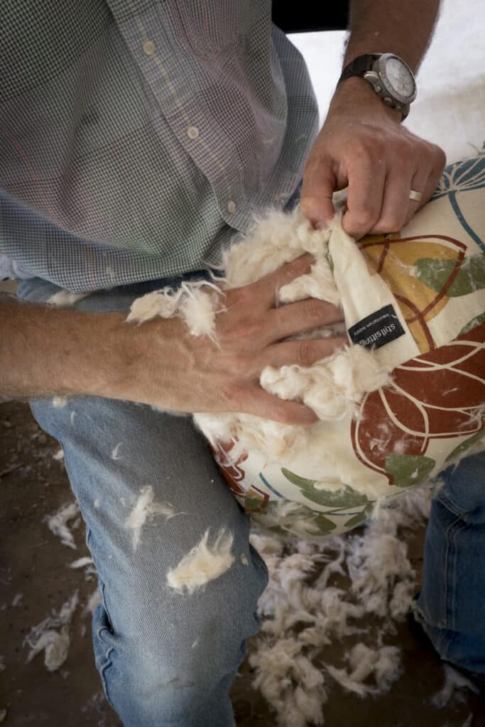 Stuffing kapok into a zafu meditation cushion.